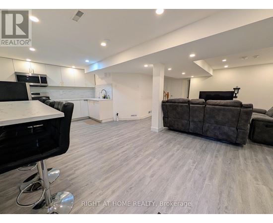 A modern living room with a grey sofa and a black chair.