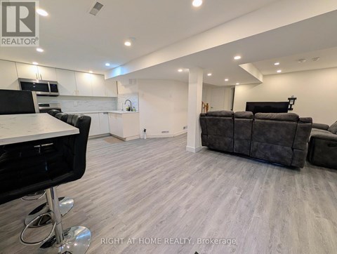 A modern living room with a grey sofa and a black chair.