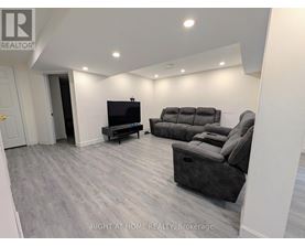 A living room with a grey sofa and a television.