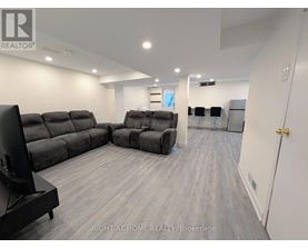 A living room with a grey sofa set and a television.