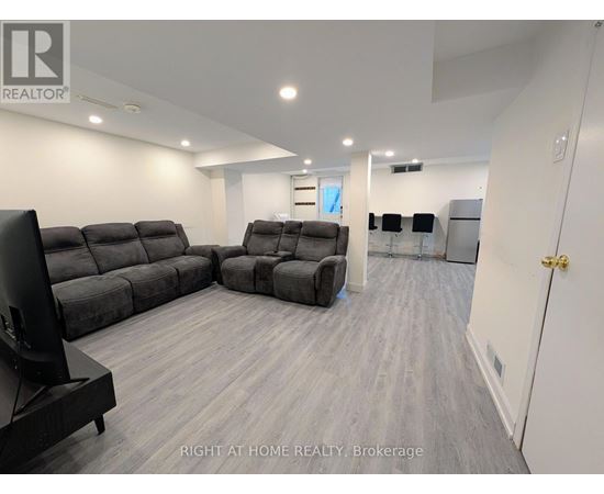 A living room with a grey sofa set and a television.
