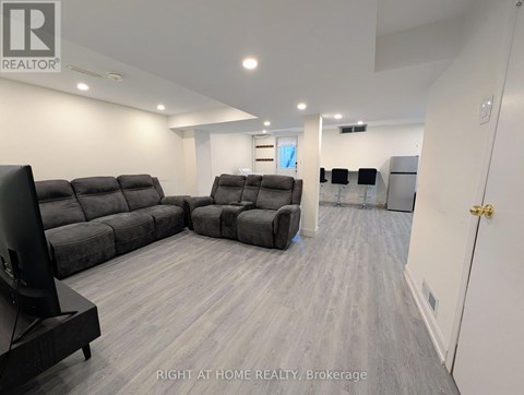 A living room with a grey sofa set and a television.