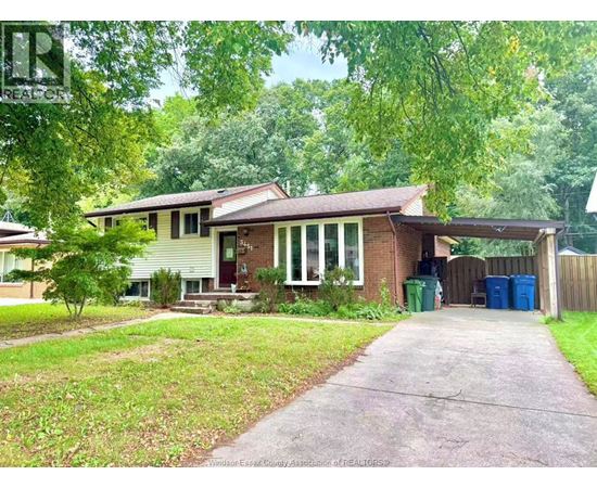 A house with a driveway and a green trash can.