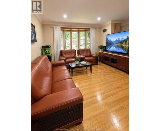 A living room with a brown leather couch and a flat screen TV.