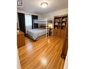 A bedroom with a bunk bed and wooden floors.