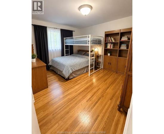 A bedroom with a bunk bed and wooden floors.