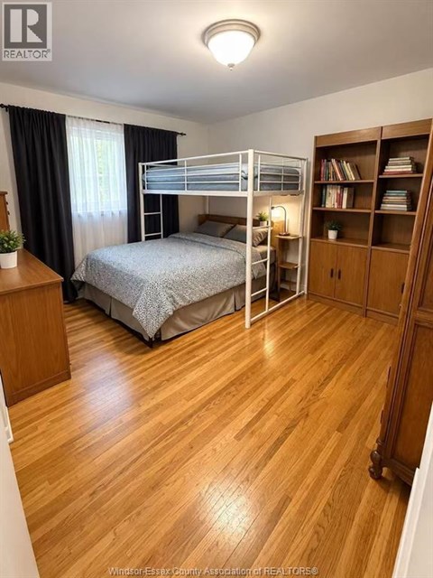 A bedroom with a bunk bed and wooden floors.