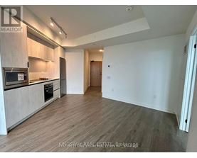 A spacious kitchen with wooden flooring and modern appliances.