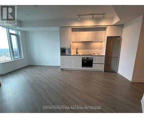 A kitchen area with a sink, stove, and cabinets.