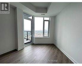 A room with a view of the city through a large window.