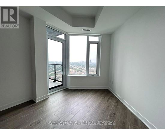 A room with a view of the city through a large window.
