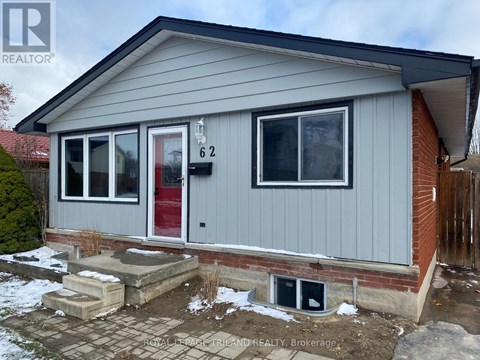 A grey house with a red door and a number 62 on it.