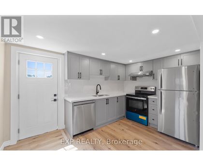 A kitchen with a white door and a window.
