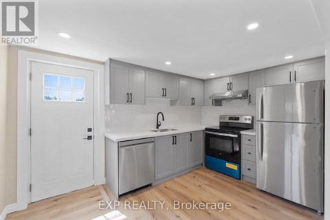 A kitchen with a white door and a window.