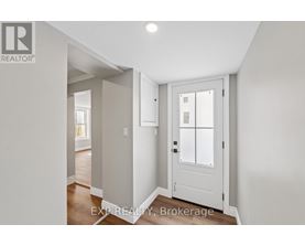 A white door with a glass panel is in a room with white walls.