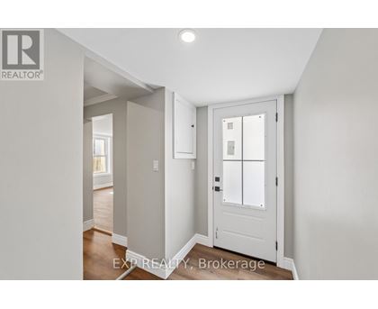 A white door with a glass panel is in a room with white walls.