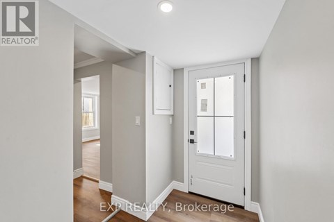 A white door with a glass panel is in a room with white walls.