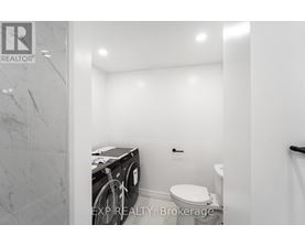 A small bathroom with a toilet and a washing machine.