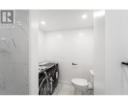 A small bathroom with a toilet and a washing machine.