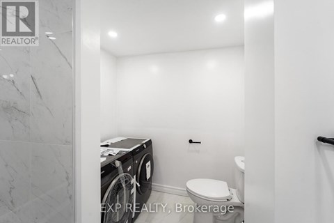A small bathroom with a toilet and a washing machine.
