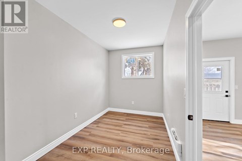 A room with a wooden floor and a white door.