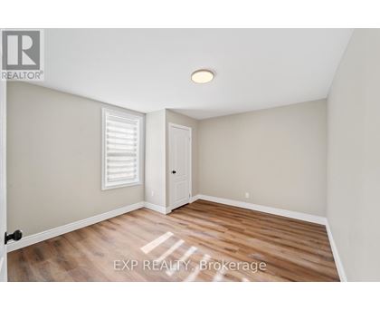 A room with wooden flooring and a white door.