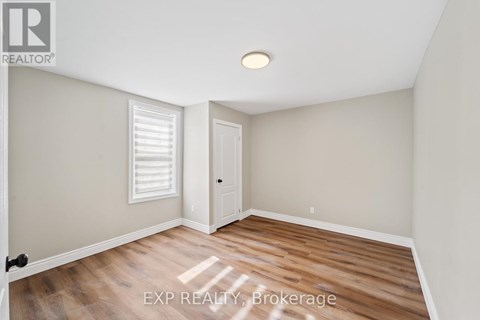 A room with wooden flooring and a white door.