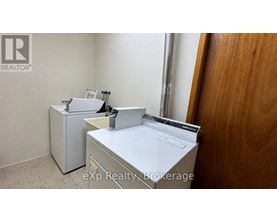 A white washing machine and dryer in a small room.