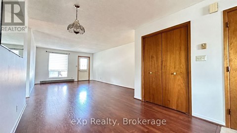 A room with a wooden floor and a ceiling light fixture.