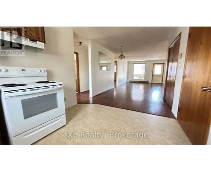 A kitchen with a white stove and a large open space.