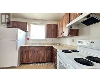 A kitchen with a white stove top oven and a white refrigerator.