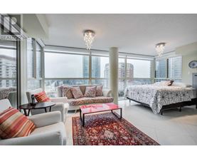 A bedroom with a large bed and a view of the city.
