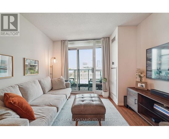 A living room with a grey couch and a brown ottoman.