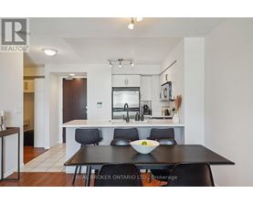A modern kitchen with a dining table set for two.