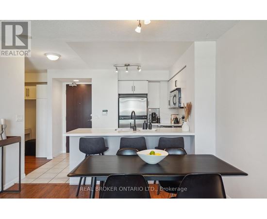A modern kitchen with a dining table set for two.