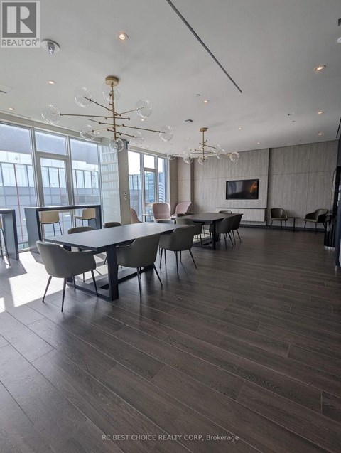 A dining room with a large table and chairs.
