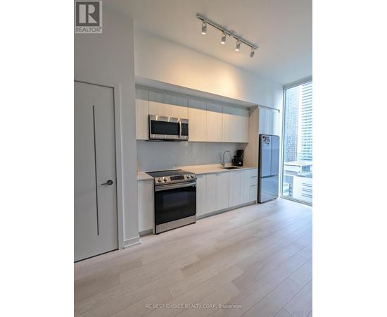 A modern kitchen with white cabinets and stainless steel appliances.