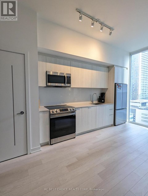 A modern kitchen with white cabinets and stainless steel appliances.