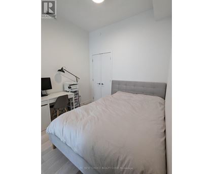 A bedroom with a bed, desk, and chair.