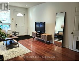 A living room with a TV and a mirror.
