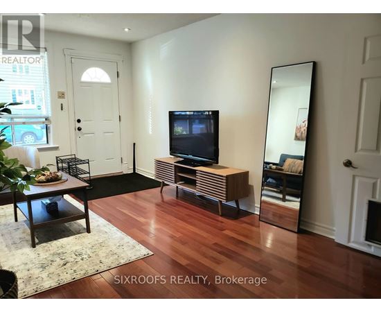 A living room with a TV and a mirror.