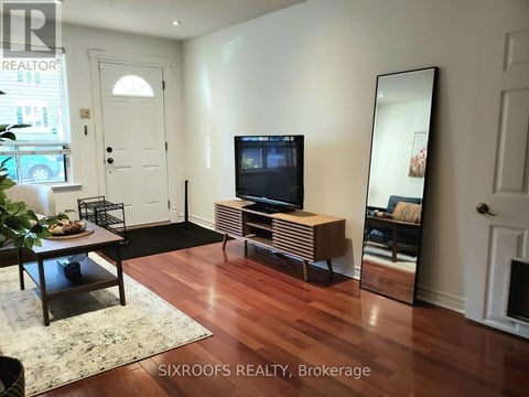 A living room with a TV and a mirror.