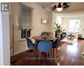 A dining room with a table and chairs.
