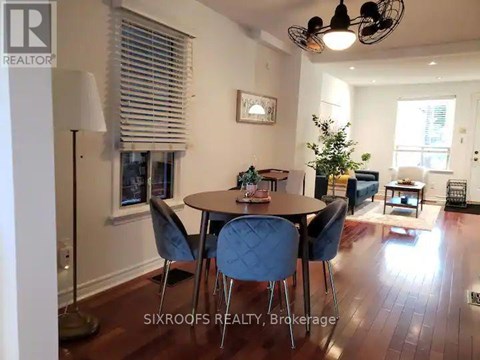 A dining room with a table and chairs.