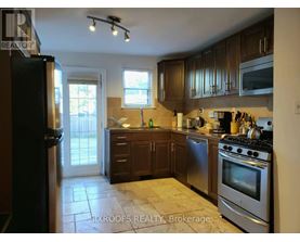 A kitchen with a stove top oven and a refrigerator.