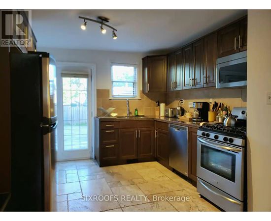 A kitchen with a stove top oven and a refrigerator.