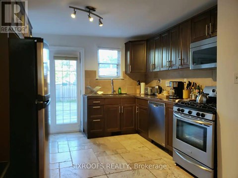 A kitchen with a stove top oven and a refrigerator.