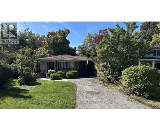 A house with a driveway and trees in the background.