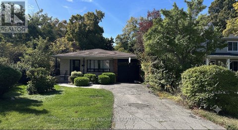 A house with a driveway and trees in the background.
