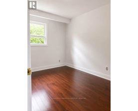 A room with wooden floors and a window letting in light.